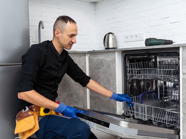 image 10 A man in blue gloves is fixing the dishwasher.
