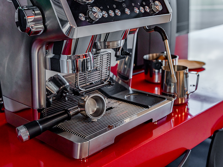 A red coffee machine with some cups on top of it