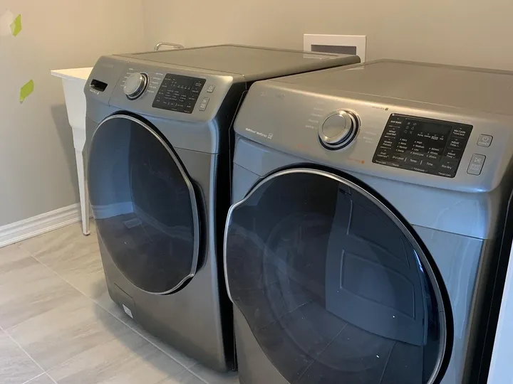 A pair of silver washer and dryer in a room.